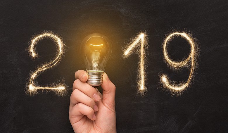 Man hand holding light bulb with 2019 year New Year 2019. Man hand holding light bulb with year number over black background