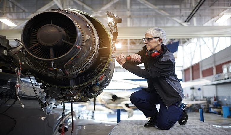 Aircraft mechanic in the hangar Senior female engineer in the hangar repairing and maintaining airplane jet engine.