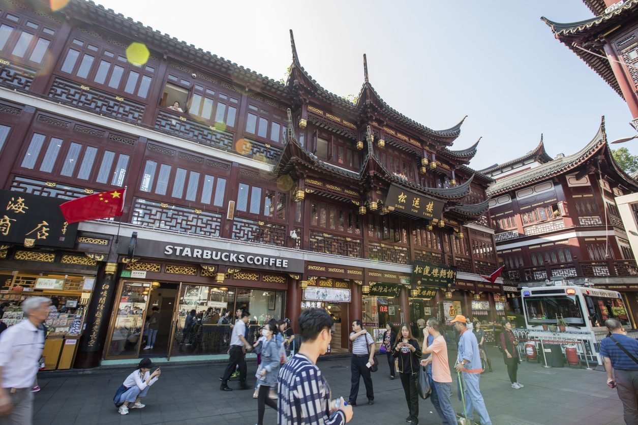 Inside Yu garden, Shanghai, China Inside Yu garden, Shanghai, China. Starbucks coffee shop among other food and drink stores in the traditional style buildings. A lot tourists in the front of the building.
